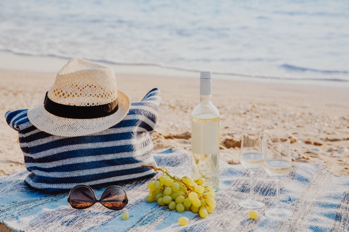 Picnic background with bag, grape and white wine by blue sea beach picnic